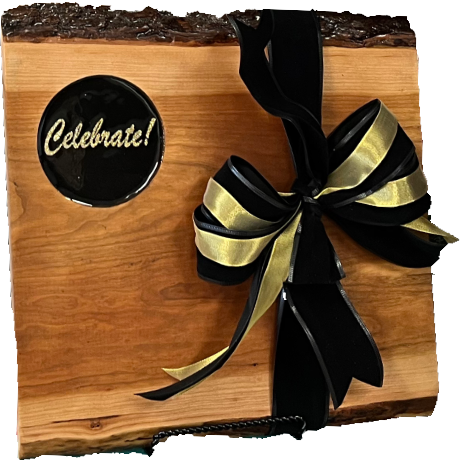 Rustic Live edge Cherry hard wood board featuring 3D printed text “Celebrate” encased in food grade resin. Elegant Black and Gold artwork.